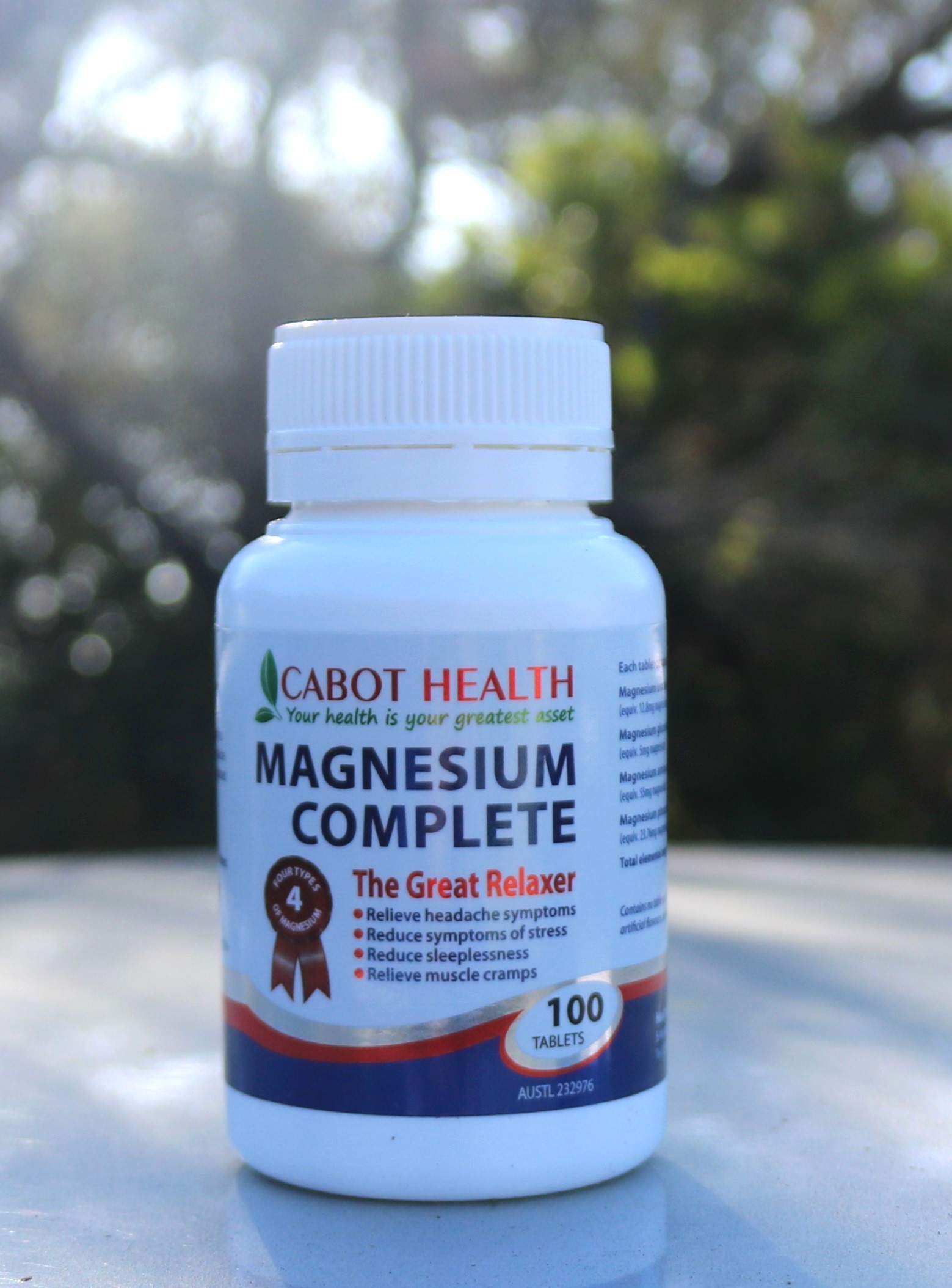 A bottle of Cabot Health Magnesium Complete tablets, labeled as "The Great Relaxer." The label highlights benefits such as relieving headache symptoms, reducing stress, improving sleep, and relieving muscle cramps. The bottle contains 100 tablets.
